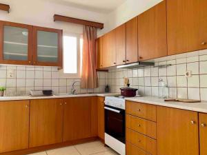 cocina con armarios de madera y horno con fogones en Elgreco Apartment, with nice view, in Kos Town "12", en Cos