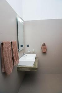 a bathroom with a white sink and a mirror at Victoria Hideout in Digana