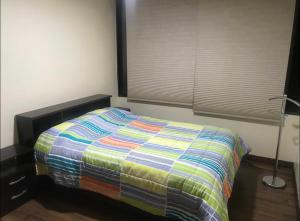 Una cama con un edredón colorido en un dormitorio en Habitaciones MAAZ, en Quito