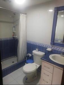 a bathroom with a toilet and a sink and a shower at Habitaciones MAAZ in Quito