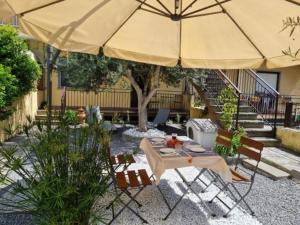 une terrasse avec un parasol, une table et des chaises dans l'établissement Chicca sul lago di Bolsena, à Bolsena