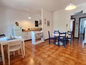 a living room with a table and chairs and a kitchen at Chicca sul lago di Bolsena in Bolsena