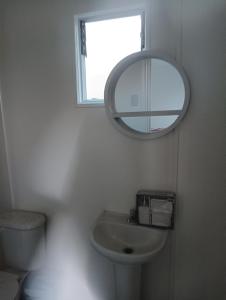 a bathroom with a sink and a mirror on the wall at Container home in Santa Teresa de Lo Ovalle