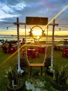 um gazebo na praia com o pôr do sol ao fundo em Casinha Vilarejo em Cabo Frio