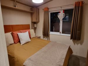 1 dormitorio con cama y ventana con almohada cardiaca en Kimadalyn en Forfar