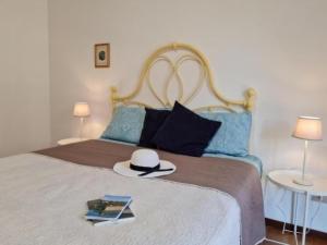 a bed with a hat and a book on it at Chicca sul lago di Bolsena in Bolsena