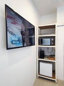 Un televisor de pantalla plana colgado en una pared en Room near the sea, en Marbella 7 fotos más