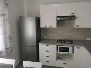 una cocina con nevera de acero inoxidable y armarios blancos en Apartman Marie, en Čavle
