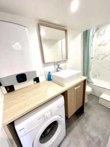 uma casa de banho com uma máquina de lavar roupa e um lavatório em Saint Leonard em Nantes