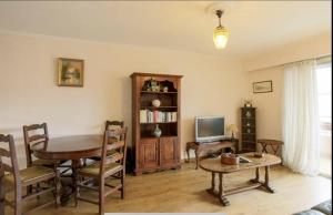 een woonkamer met een tafel en een televisie bij Spacious Apartment in Vallauris for Art Lovers in Vallauris