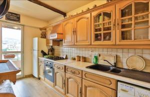 een keuken met houten kasten, een wastafel en een koelkast bij Spacious Apartment in Vallauris for Art Lovers in Vallauris