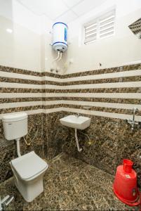 La salle de bains est pourvue de toilettes et d'un lavabo. dans l'établissement Ventex Inn, à Lucknow