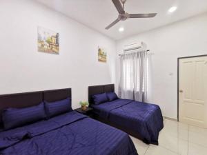 a bedroom with two beds and a ceiling fan at Bdr Seri Botani ipoh-nordic (tvbox/mahjong 19pax) in Ipoh