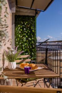 una mesa de madera con 2 platos de comida en el balcón en Da Don Antonio, en Nápoles
