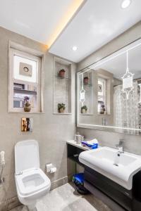 a bathroom with a sink and a toilet and a mirror at Pentagon - 5 Bedroom Apartment Saket, South Delhi in New Delhi