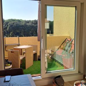 Cette chambre dispose d'une fenêtre offrant une vue sur une table. dans l'établissement Studio climatisé cosy avec grande piscine chauffée, au Cap d'Agde