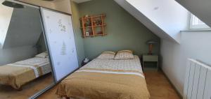 a attic bedroom with two beds and a mirror at Maison lumineuse dans un cadre verdoyant in Saint-Prix +10 photos