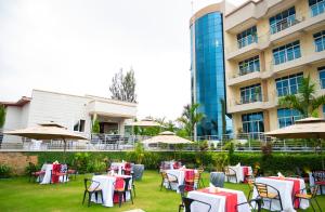 a hotel with tables and chairs in front of a building at Madras Hotel and Apartments in Kigali