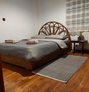 a bedroom with a large bed with a wooden headboard at Fori's Nest / SKG in Thessaloniki