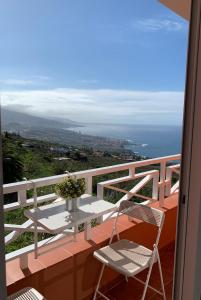 un tavolo e sedie su un balcone con vista sull'oceano di Vivienda vacacional Las Cañas a Santa Úrsula