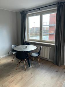 a dining room with a table and chairs and a window at Apartament Stara Motława in Gdańsk