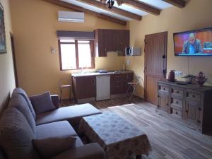 sala de estar con sofá y cocina en El Majano, en Montánchez