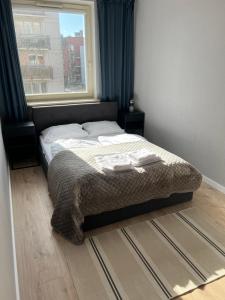 a bed sitting in a bedroom with a window at Apartament Stara Motława in Gdańsk