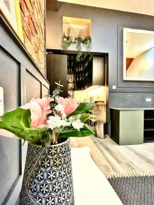 a vase filled with flowers on a table in a room at AdeamStays provides Beautiful centrally located 1 and 2 bed apartments on Liverpools Boulevard in Liverpool