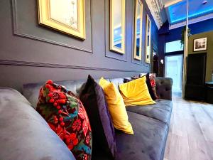 a living room with a gray couch with yellow pillows at AdeamStays provides Beautiful centrally located 1 and 2 bed apartments on Liverpools Boulevard in Liverpool