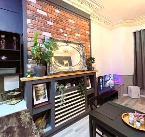 sala de estar con espejo en una pared de ladrillo en AdeamStays provides Beautiful centrally located 1 and 2 bed apartments on Liverpools Boulevard, en Liverpool