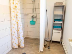 a bathroom with a shower with a shower curtain at Bungalow Neues Atelier in Lubmin +10 photos