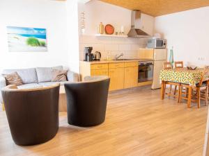 Bungalow Neues Atelier في لوبمين: مطبخ وغرفة معيشة مع أريكة وطاولة