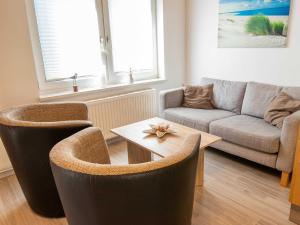 uma sala de estar com um sofá e uma mesa em Bungalow Neues Atelier em Lubmin