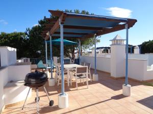 uma pérgola num telhado com uma mesa e cadeiras em Farol da Cortesia - Praia Verde em Praia Verde