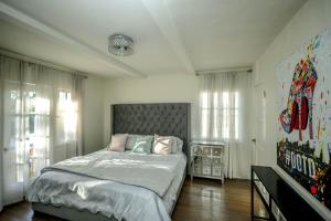 a bedroom with a large bed and some windows at Grand Spanish 3BD 2BA near West Hollywood and Beverly Hills in Los Angeles