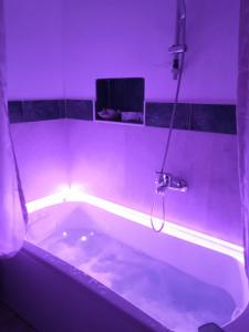 y baño con bañera con iluminación púrpura. en Affittacamere Sapore di Mare, en Talsano