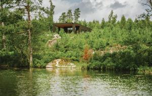 una casa en una colina junto a un cuerpo de agua en Beautiful Home In Holmsj With Wifi en Holmsjö