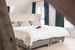 1 dormitorio con 1 cama blanca grande y mesa en MAM Haspengouw en Sint-Truiden