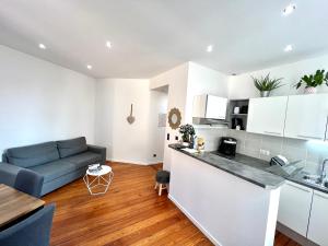 a kitchen and a living room with a blue couch at HYPER CENTRE - Colmar Cathédrale - PARKING Gratuit in Colmar +10 photos
