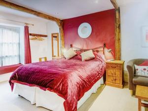 um quarto com uma cama grande e uma parede vermelha em The Boat House Bed and Breakfast em Laugharne
