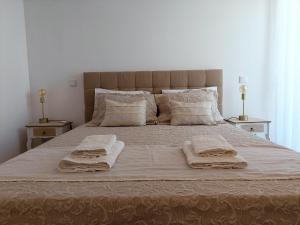 a bedroom with a large bed with two towels on it at Villa Algarve in Alcantarilha