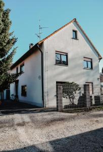 a white house with a fence in front of it at Anca's Haus in Schwanstetten