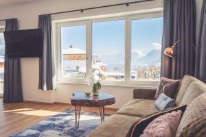 a living room with a couch and a large window at Anna Pertl - lieblingsquartier in Sankt Gilgen