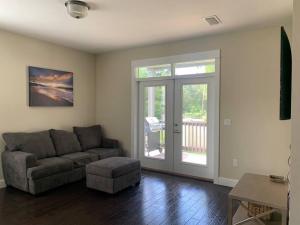 a living room with a couch and a sliding glass door at 30A Coastal Home Walk to Beach, Lake & Pool in Inlet Beach