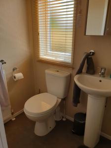 a bathroom with a white toilet and a sink at Kimadalyn in Forfar
