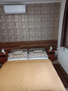 A bed or beds in a room at Boglárka Vendégház