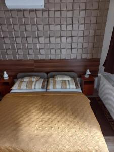 A bed or beds in a room at Boglárka Vendégház