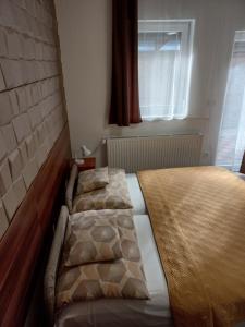 A bed or beds in a room at Boglárka Vendégház