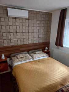 A bed or beds in a room at Boglárka Vendégház