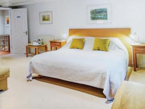 ein Schlafzimmer mit einem großen weißen Bett mit gelben Kissen in der Unterkunft The Boat House Bed and Breakfast in Laugharne